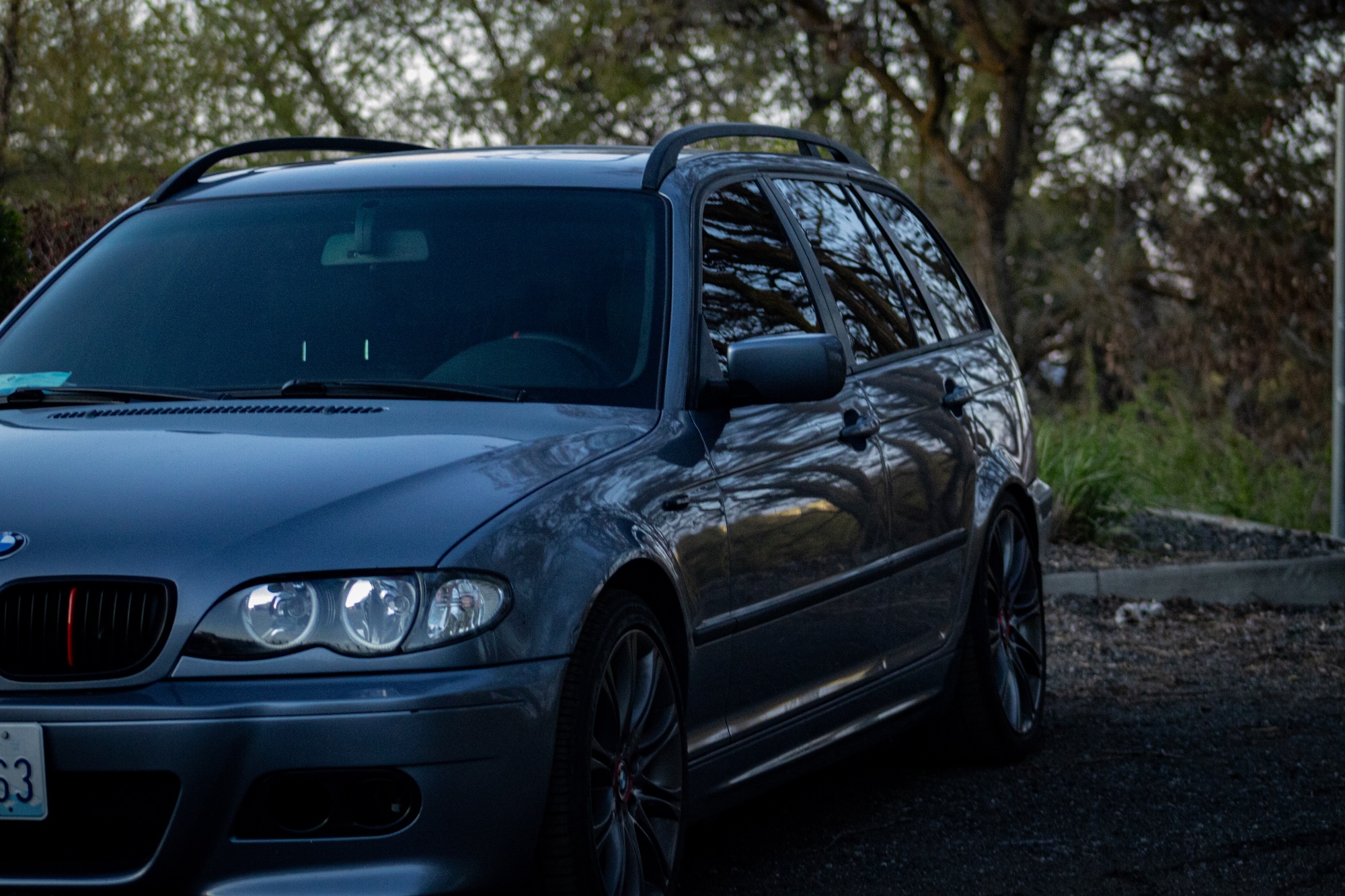 BMW E46 with headlights and marker lights on during dusk